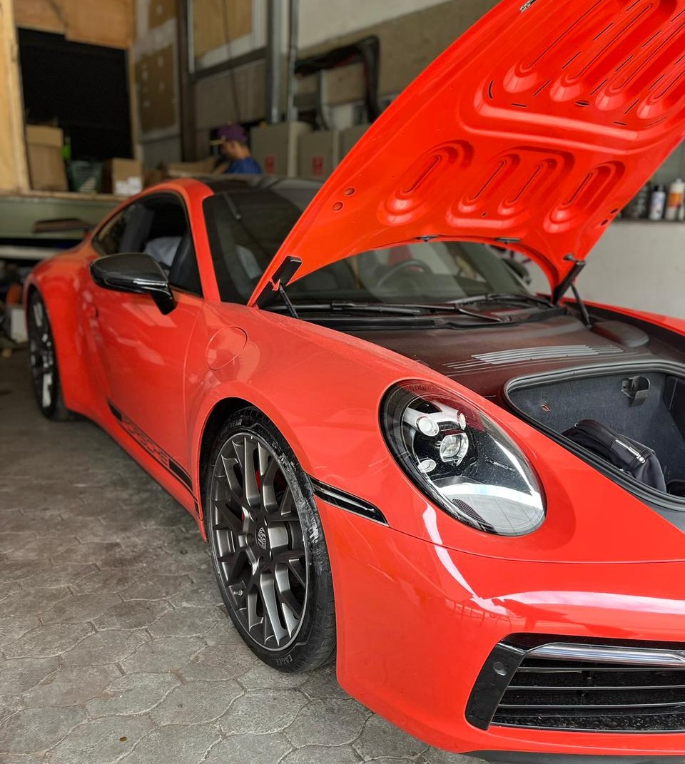 Profissional aplicando polimento em carro preto